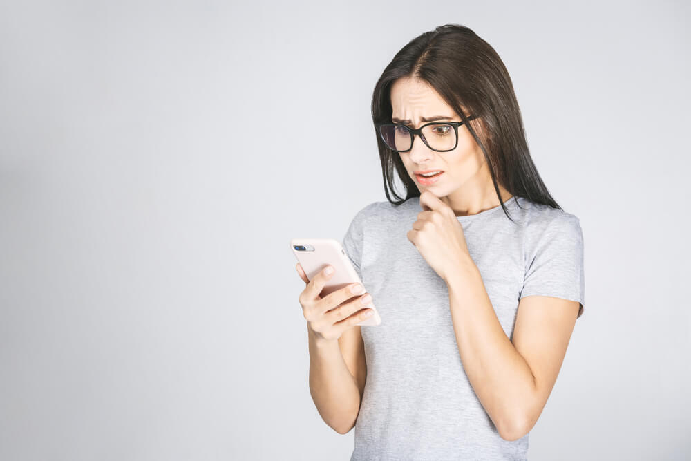 Look woman перевод. Shutterstock Shocked blonde Lady Jacket taking selfie stock photo 1415936996 | Shutterstock. Girls looking at you. Shocked women to look Cloth. Girl's looking at smartphone White Wall.