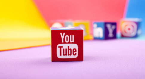 kostka z logo YouTube na kolorowym tle.