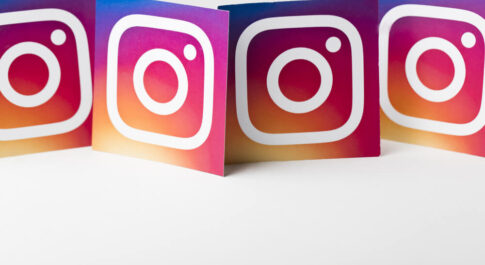 Kartki z logo Instagrama, poustawiane są obok siebie w rzędzie. Na białym tle.