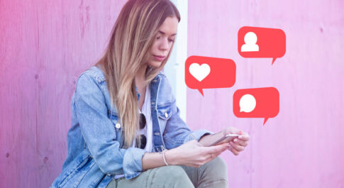 Dziewczyna o blond włosach siedzi na murku i trzyma w rękach telefon. Nad telefonem unoszą się trzy ikony oznaczające polubienia, nowego obserwatora i komentarz.