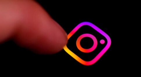 logo Instagrama na czarnym tle, które wskazuje palec.