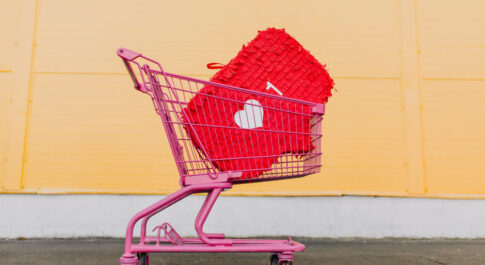 Różowy koszyk zakupowy, w którym jest ikona oznaczająca nowe polubienie posta na Instagramie.