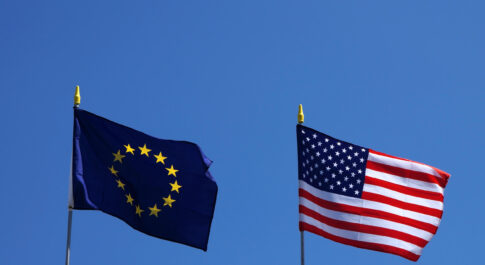 flagi Unii Europejskiej i Stanów Zjednoczonych na tle błękitnego nieba