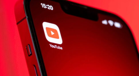 Logo YouTube na telefonie. Czerwone tło.