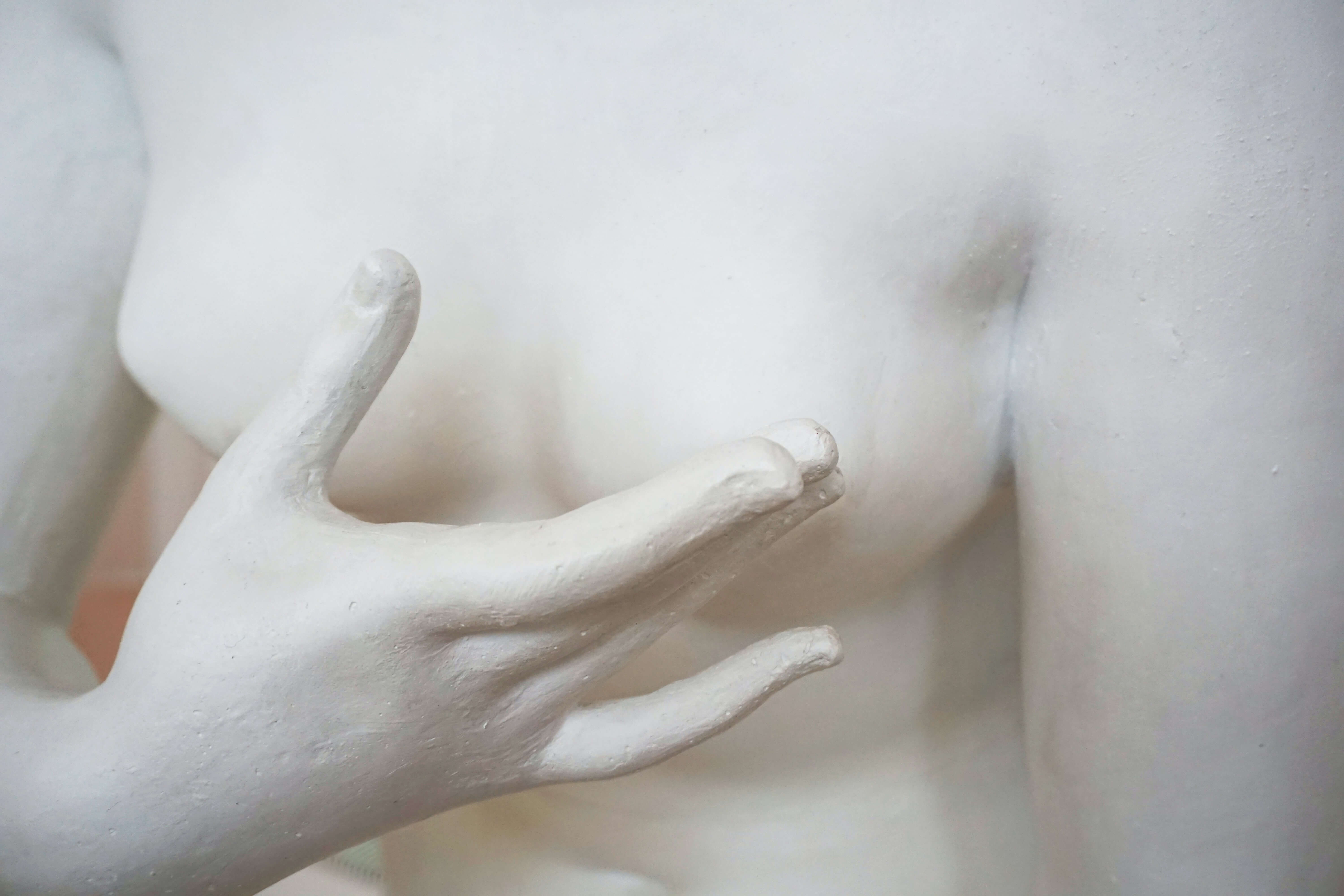 Biała figura zakrywająca dłonią sutek